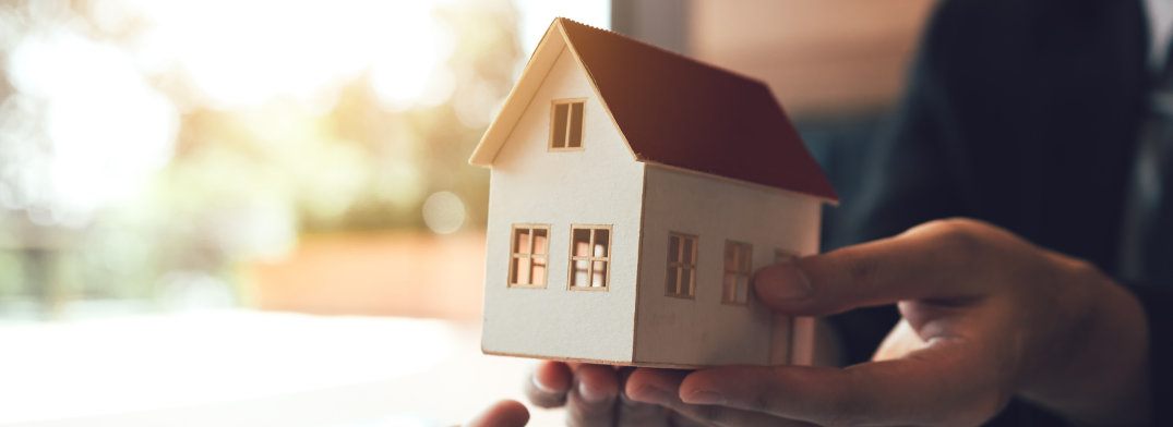 Image showing person handing small wooden house, representing handing over an estate.